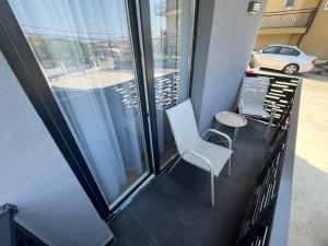 a balcony with a white chair and a table at HUGO House Luxury & Quiet - Free Parking in Zalău