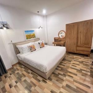a bedroom with a white bed and a wooden cabinet at Stingless Villa in Ban Ket Ho +6 photos