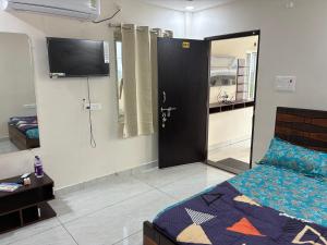 a room with a bed and a door with a television at V guesthouse staycation in Bāpatla
