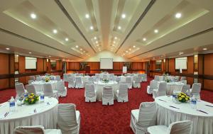 een feestzaal met witte tafels en witte stoelen bij Eagleton The Golf Resort in Bangalore +98 foto's