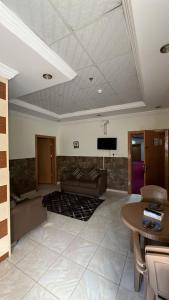 a living room with a couch and a tv on the ceiling at شموخ العلياء للشقق المخدومة in Al Jith