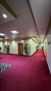 a large room with a red carpet and potted plants at شموخ العلياء للشقق المخدومة in Al Jith