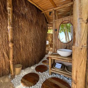un bagno con un lavandino e uno specchio in una capanna di Cambaya Beach Resort a Busuanga