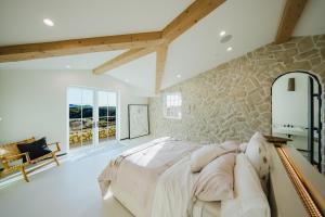 a bedroom with a large bed and a stone wall at Mintcello Estate in Malibu