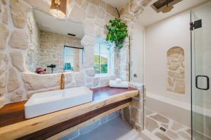 a bathroom with a sink and a stone wall at Mintcello Estate in Malibu +37 photos