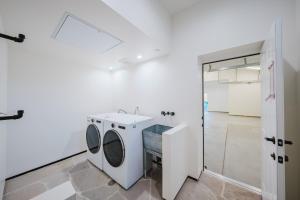 a bathroom with a washing machine and a sink at Mintcello Estate in Malibu