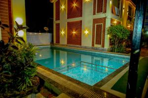 ein Swimmingpool vor einem Haus bei Nacht in der Unterkunft Xylem Sea Side Resort in Puri