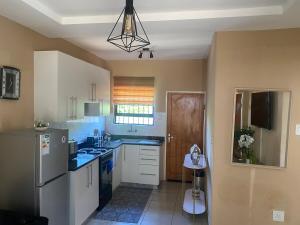 une cuisine avec un évier et un réfrigérateur dans l'établissement Cozy Haven in Manzini, à Manzini