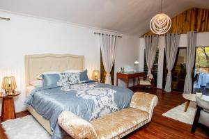 een slaapkamer met een groot bed en een bank bij The Sissing Santuary 