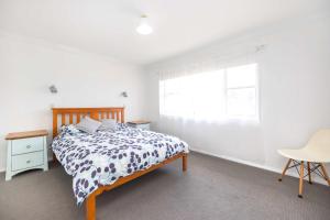 een slaapkamer met een bed en een raam bij Rennies Beach Escape "Carinya" in Ulladulla +16 foto's