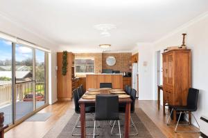een keuken en eetkamer met een tafel en stoelen bij Rennies Beach Escape "Carinya" in Ulladulla