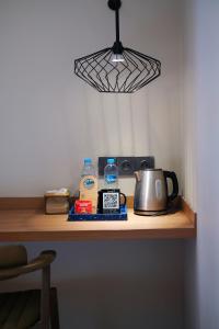 a table with a tea kettle and water and a light at Samai Suites in Bandar Lampung