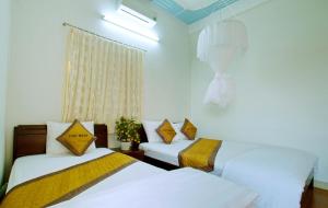 a bedroom with two beds and a window at Thu Bon Riverside Homestay in Hoi An