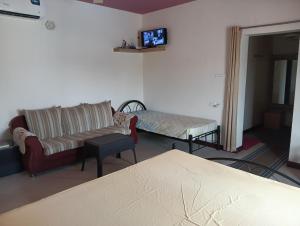 a living room with a couch and a bed at MANTRAs in Mysore