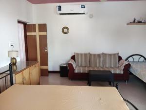 a living room with a couch and a bed at MANTRAs in Mysore