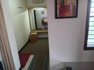 a hallway leading to a bathroom with a mirror at MANTRAs in Mysore