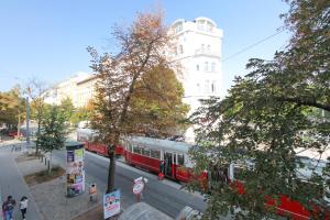 a red and white train on a city street at Ana Maria Apartments in Vienna