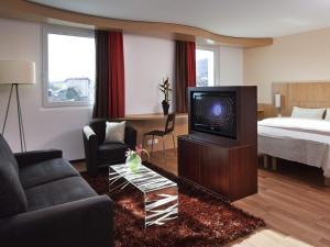 ein Wohnzimmer mit Fernseher und Bett in der Unterkunft ibis Delémont in Delémont + 46 Fotos