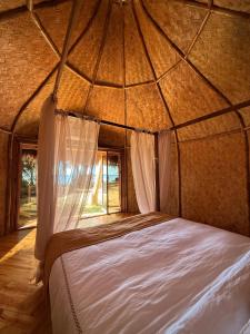 una camera da letto di una yurta con un letto al suo interno di Cambaya Beach Resort a Busuanga