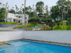 a house with a swimming pool in front of a house at Lilliput Haven Homestay in Sultan Bathery
