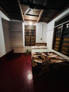 ein Schlafzimmer mit einem Bett in einem Zimmer mit Fenstern in der Unterkunft Idam Homestay - Entire 3 Bedroom Holiday Home in Idukki