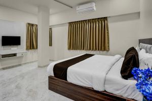 a bedroom with a large bed and a television at Townhouse Ganesh Tekdi Temple Nagpur in Nagpur