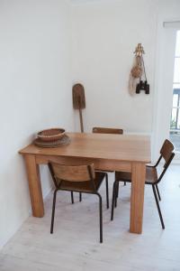 a wooden table with two chairs in a room at Gills in Murdunna