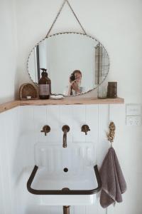 a woman taking a picture of a sink in a bathroom at Gills in Murdunna +4 photos