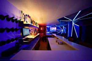 a room with a bar with purple lights on it at La Woods Hotel in Chennai +87 photos