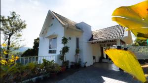 a white house with a large yellow leaf at moonlight palace private pool villa vagamon in Vagamon