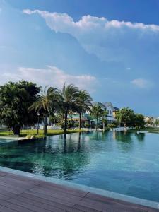 una gran piscina de agua con palmeras y casas en MYSTERY HOME - 180m2 3BEDROOM - NOVAWORLD PHAN THIET, en Phan Thiet