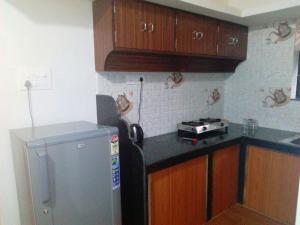 een keuken met houten kasten en een roestvrijstalen koelkast bij Nhanji House in Arambol