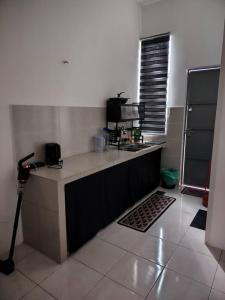 a kitchen with a sink and a counter top at Nazana Homestay in Batu Gajah