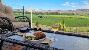 a table with a plate of food and a glass of wine at Fairhall view in Marlborough Airport