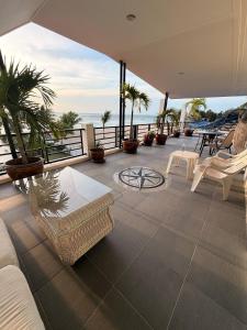 een patio met stoelen en uitzicht op de oceaan bij Romantic Beachside Retreat with Breathtaking Views in Ban Nong Hoi Siap