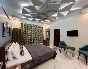 a bedroom with a bed and a ceiling fan at Karachi inn Guest in Dargai