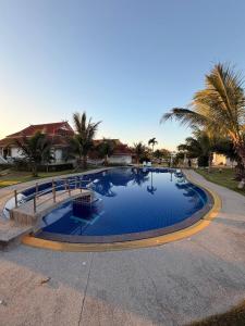 een groot zwembad met palmbomen eromheen bij Romantic Beachside Retreat with Breathtaking Views in Ban Nong Hoi Siap