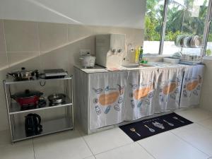 eine Küche mit einer Theke und einem Tisch mit einer Theke in der Unterkunft Kuala Selangor Moonlight Sweet Home Semi-D 20Pax in Kuala Selangor