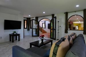 een woonkamer met een bank en een tv bij Nature's Hill side Phana House in Ban Nong Chaeng