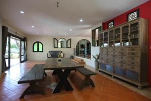 een grote eetkamer met een houten tafel en banken bij Nature's Hill side Phana House in Ban Nong Chaeng