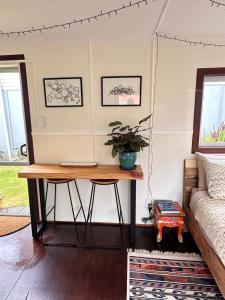 een tafel in een woonkamer met een bank bij Pandora Cottage Beachfront in Raglan