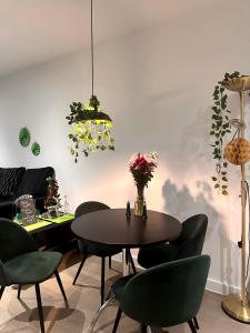 a dining room with a table and green chairs at Redheema in Lower Sydenham Station