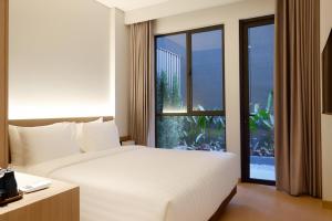 a bedroom with a white bed and a large window at The Artha - Bandung in Bandung +61 photos