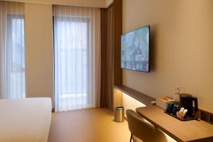 a hotel room with a television on the wall at The Artha - Bandung in Bandung