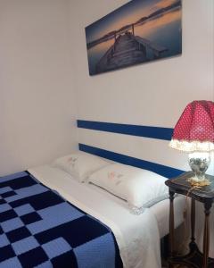 a bedroom with a bed with a blue and white stripes at AA Central Station Historical center in Palermo