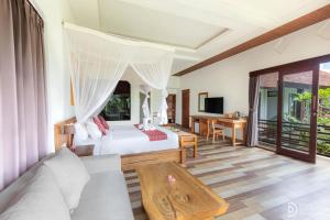 una camera da letto con un letto e una scrivania in una stanza di Green Sala Villa ad Ubud