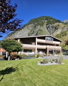 a large building with a mountain in the background at ötztalLOFT in Längenfeld