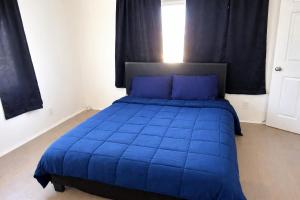 ein blaues Bett mit blauen Kissen im Schlafzimmer in der Unterkunft Hollywood Comfort Vibe LA in Los Angeles