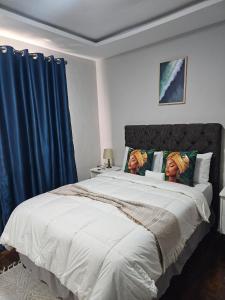 Twee vrouwen zitten op een groot bed. bij Phozi Inn in Eshowe