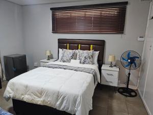 een slaapkamer met een groot bed en een ventilator bij Phozi Inn in Eshowe